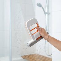 Flowipe limpiando la mampara de vidrio de una ducha sin mojarse las manos