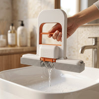 Mano tirando de la manija de Flowipe para exprimir el agua sobre un lavabo, sin mojarse las manos